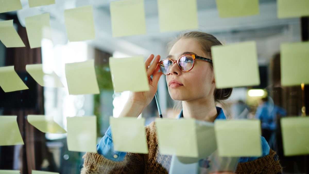 Femme d'affaires lisant des rappels au bureau