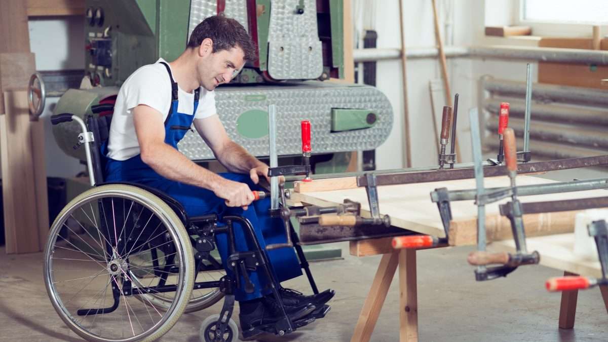Worker in wheelchair in a carpenter's workshop.