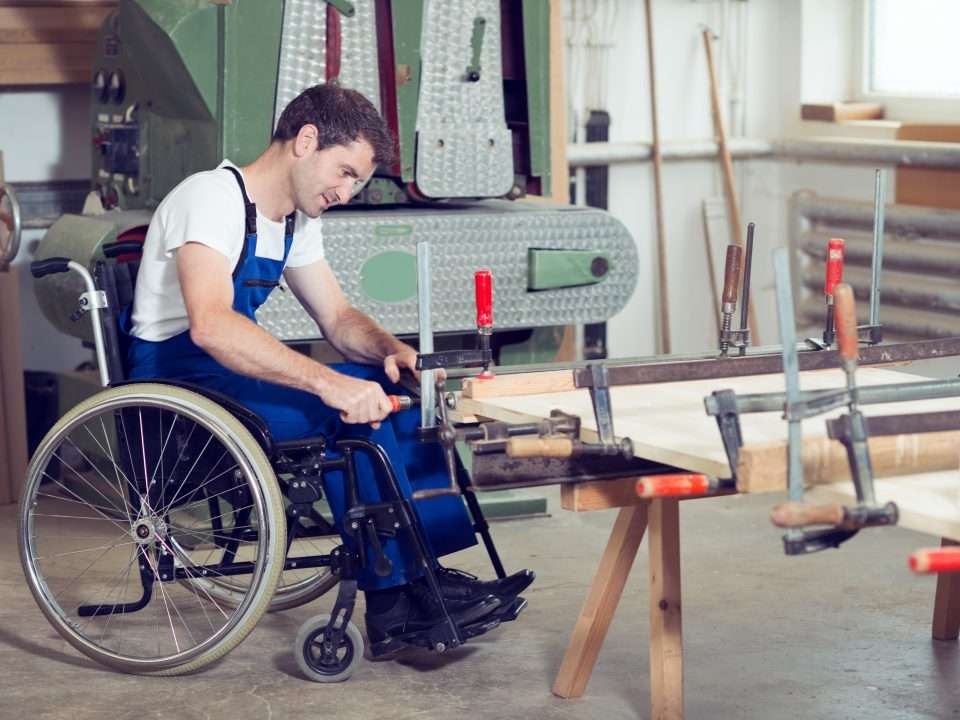 Worker in wheelchair in a carpenter's workshop.