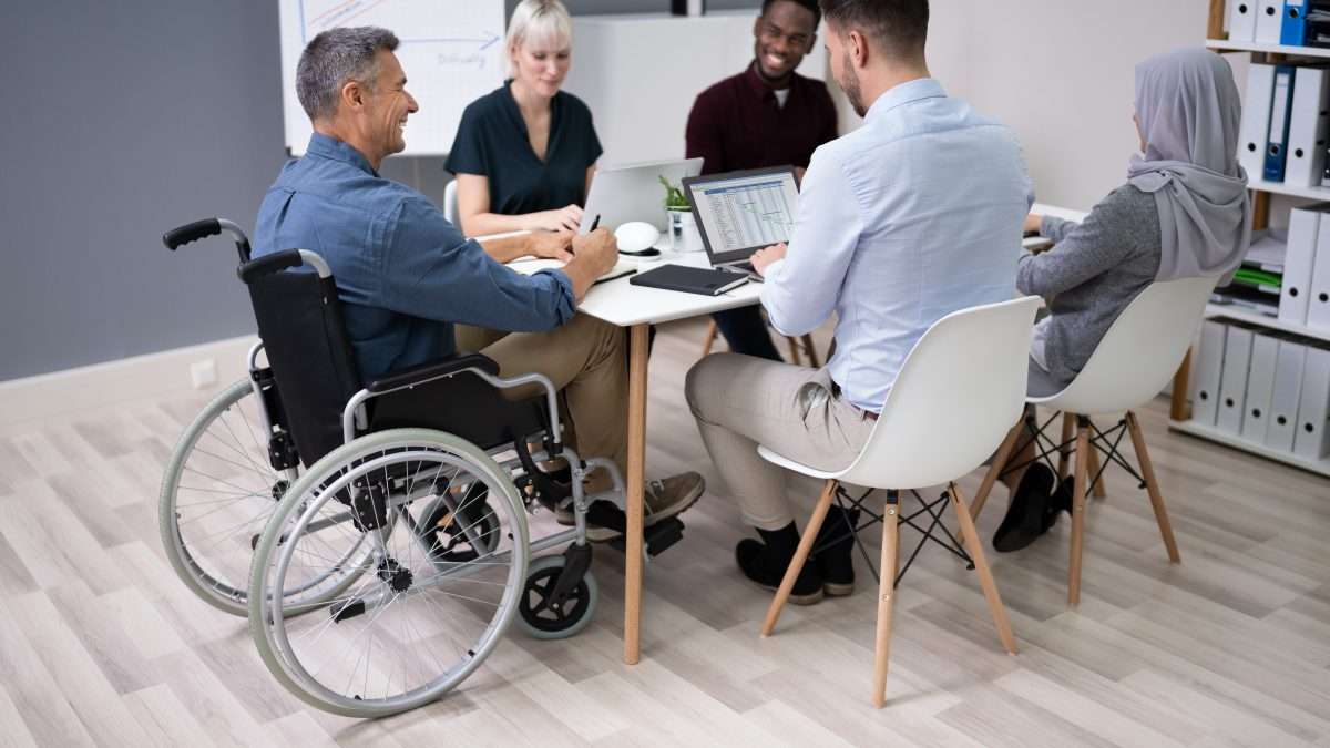 A diverse group of employees gather for a meeting.