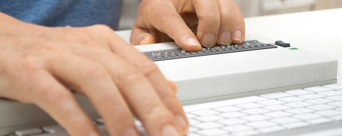 Image of hands typing on braille keyboard
