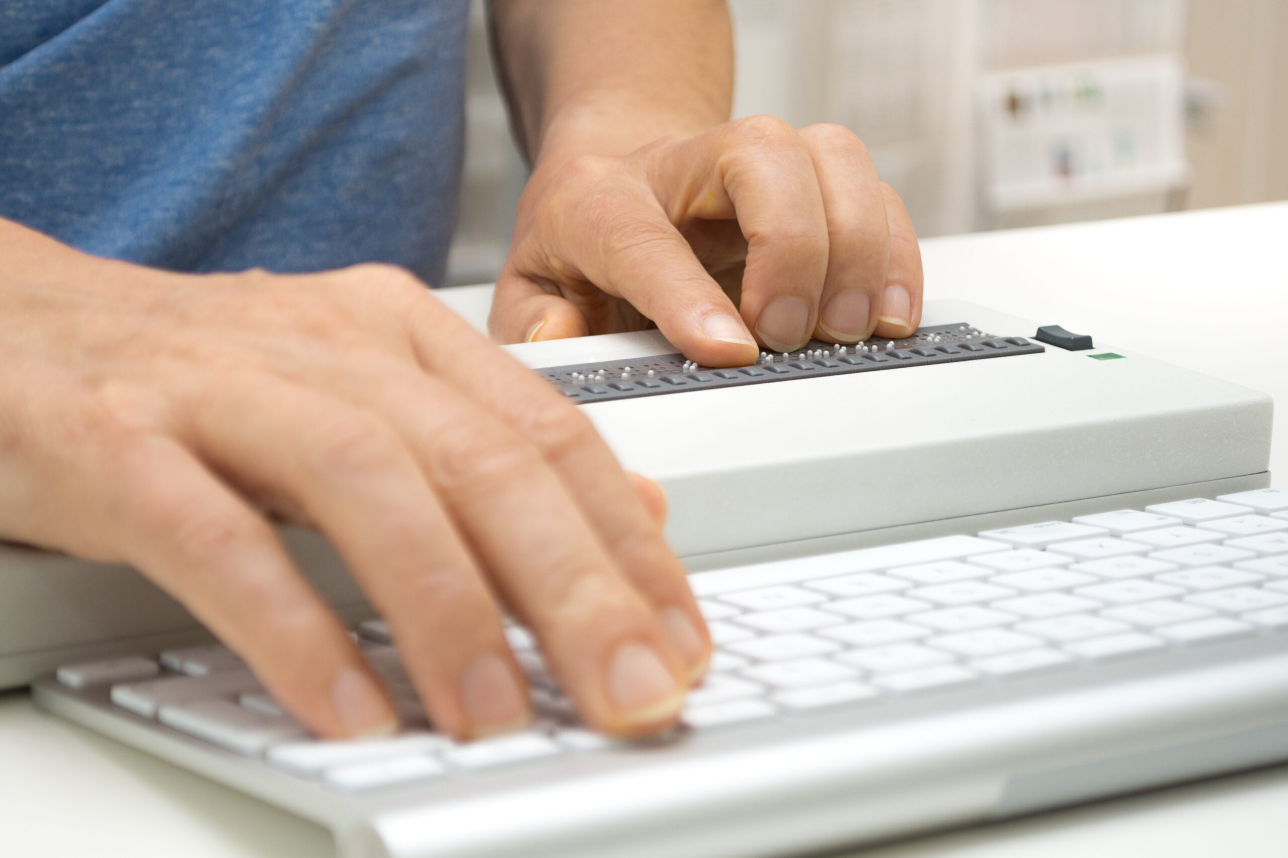 Image of hands typing on braille keyboard
